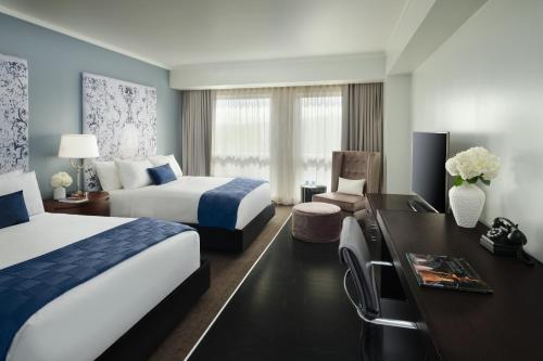 a hotel room with two beds and a desk at The Fontaine in Kansas City