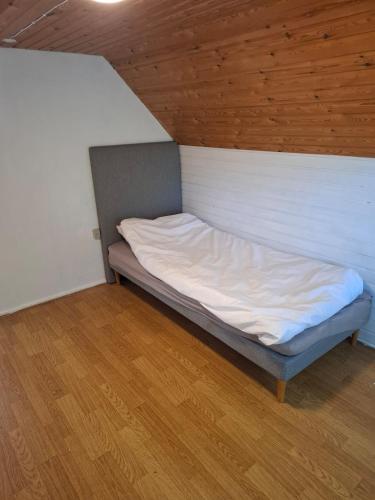 ein kleines Bett in einem Zimmer mit Holzboden in der Unterkunft kærgård in Bøvlingbjerg
