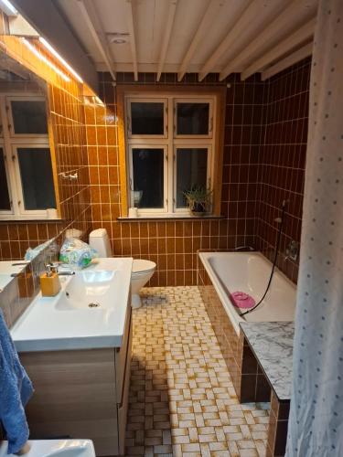 ein Badezimmer mit Badewanne, Waschbecken und Toilette in der Unterkunft kærgård in Bøvlingbjerg