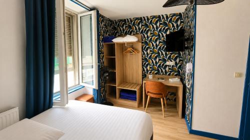 a bedroom with a bed and a desk in a room at Logis Hôtel Au Croissant in Buzançais