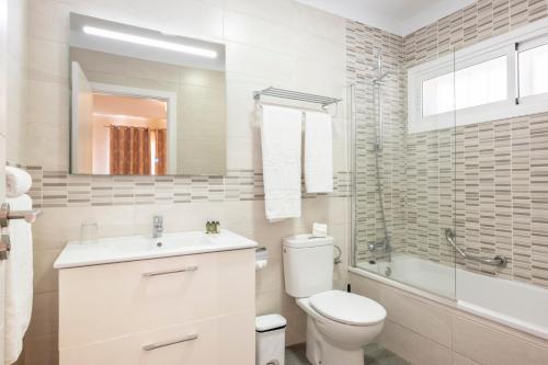 a white bathroom with a toilet and a sink at Ona Sueño Azul in Callao Salvaje