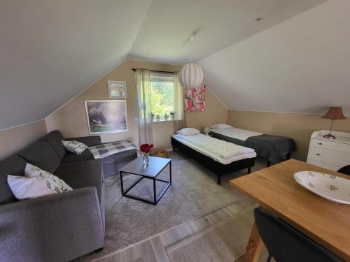 ein Wohnzimmer mit Sofa und Bett in der Unterkunft Landet in Åby