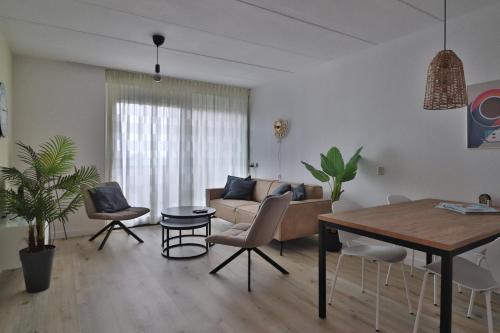 a living room with a couch and a table at Zuiderzee State - Appartementen in Makkum