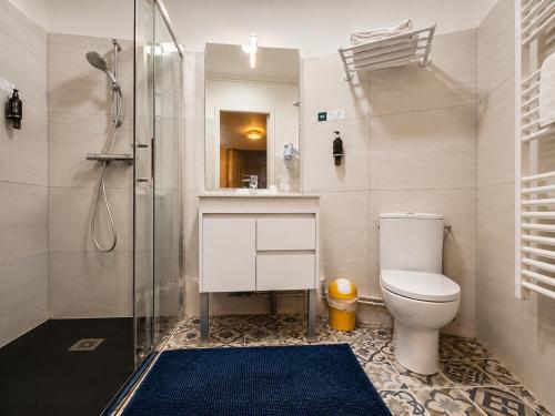 a bathroom with a toilet and a shower at Logis Hôtel Au Croissant in Buzançais