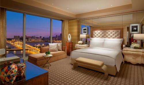 a bedroom with a large bed and a large window at Wynn Macau in Macau