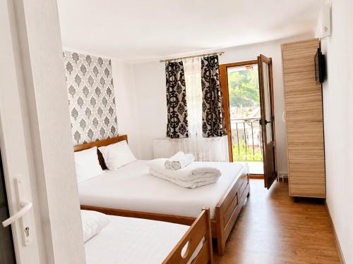 two beds in a room with a window at Pensiunea Hanzu Darius in Gura Râului
