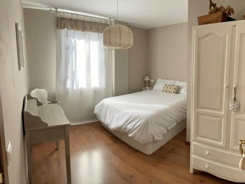 a bedroom with a bed and a desk and a window at Apartamento El Gorgol in Tramacastilla de Tena