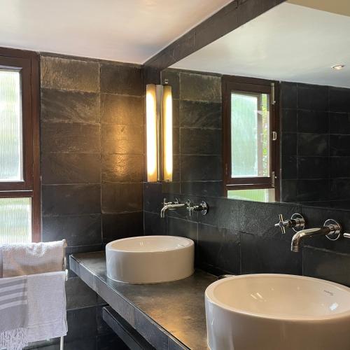 a bathroom with two sinks and two mirrors at Zaza Stay in New Delhi