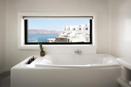 a white bath tub in a bathroom with a window at The Duchess in Therasia