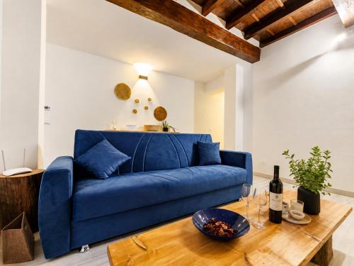 a blue couch in a living room with a table at Il Rifugio di Trip Centro Storico & Lago in Mantova