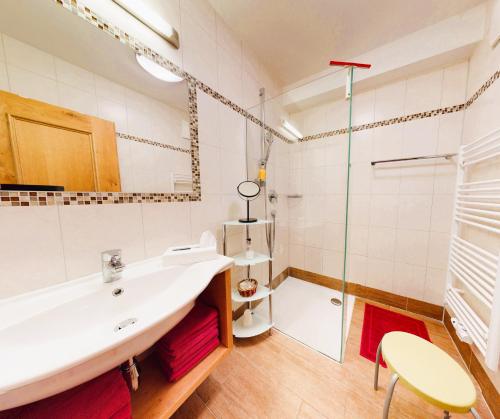 a bathroom with a tub and a sink and a shower at Landhaus Wildschwendt in Ellmau