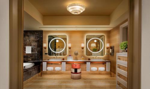 a bathroom with two sinks and two mirrors at Wynn Macau in Macau