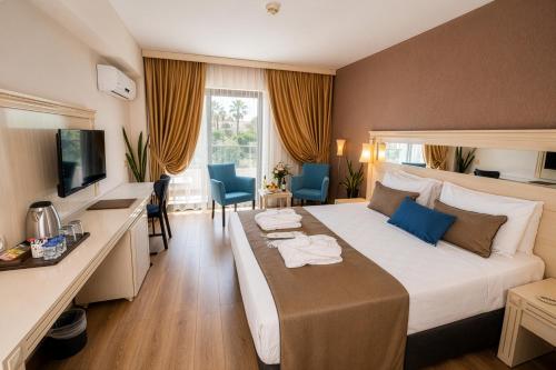 a hotel room with a large bed and a desk at Tripolis Hotel in Pamukkale