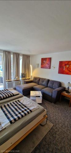 a living room with a bed and a couch at Ferienwohnung Ronja im Hause Bergland Altreichenau in Neureichenau