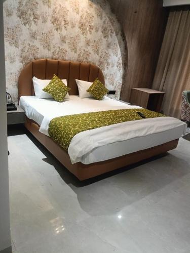 a bedroom with a large bed with a brown headboard at Mayur baag resort in Sāgar
