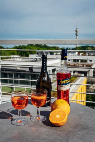Zwei Flaschen Alkohol und zwei Gläser auf einem Tisch in der Unterkunft Brera Serviced Apartments Munich Schwabing in München