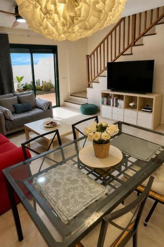 a living room with a glass table and a television at La Pituca in Playa Blanca