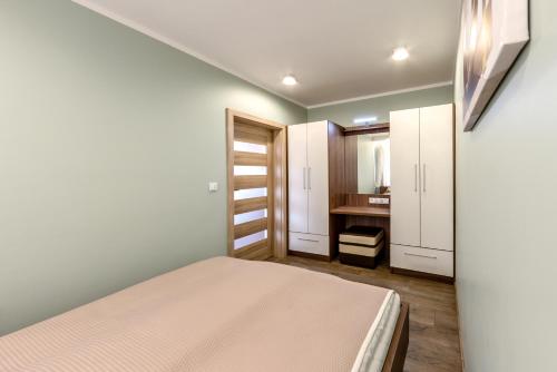 niewielka sypialnia z łóżkiem i łazienką w obiekcie Apartament Eva w mieście Karpacz