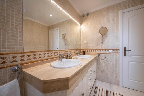 a bathroom with two sinks and a mirror at Villa Afreen Playa in Morro del Jable