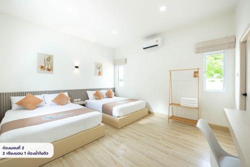a bedroom with two beds and a desk and a mirror at Seahorse poolvilla sattahip SP2 in Ban Nong Sa