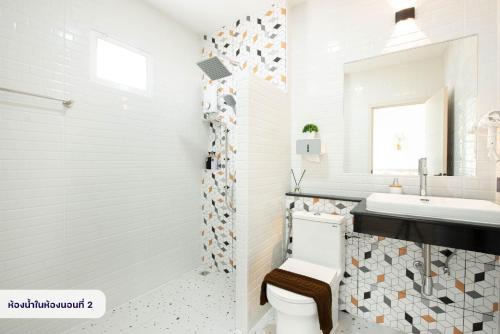 a white bathroom with a toilet and a sink at Seahorse poolvilla sattahip SP2 in Ban Nong Sa