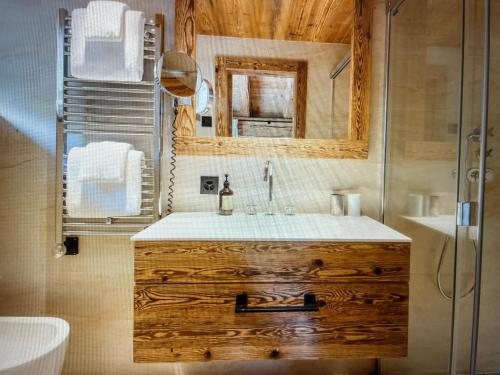 a bathroom with a wooden sink and a mirror at Arlberg View Residence in St. Moritz