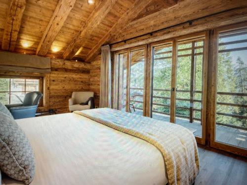 a bedroom with a bed and a large window at Arlberg View Residence in St. Moritz