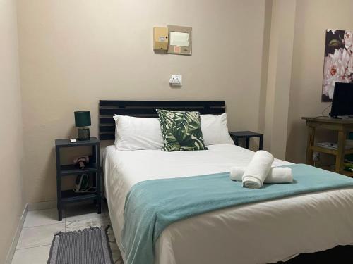 a bedroom with a large bed with white sheets at Meerensee tranquil suite in Richards Bay