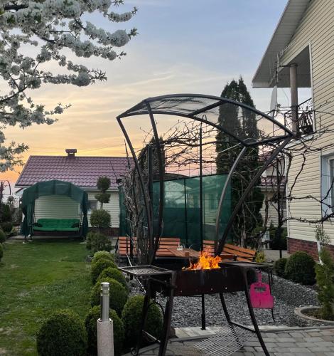 a fire pit with a bench in a yard at Cottage EcoComfort in Sagunovka