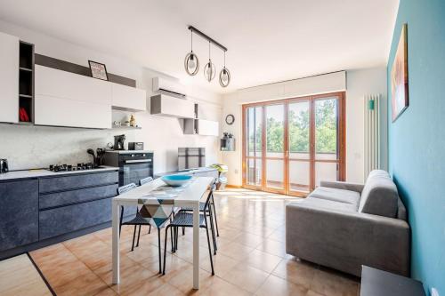 a kitchen and living room with a table and a couch at Soffio di Luce in Calderara di Reno