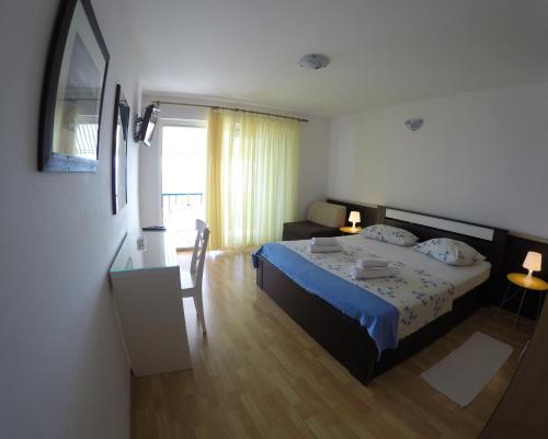 a bedroom with a bed and a table and a desk at Guest House Stipe in Brela