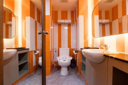 a bathroom with two sinks and a toilet in it at Azana Oasis Hotel Aceh in Luengbata