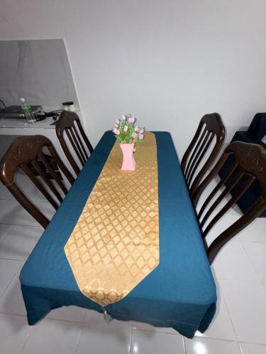 a blue table with a vase of flowers on it at AiNi's Homestay in Sipitang