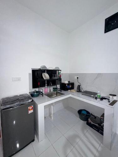 a white kitchen with a sink and a refrigerator at AiNi's Homestay in Sipitang