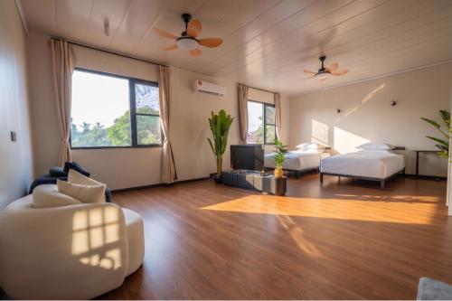 a living room with a bed and a couch and a bed and a bedroom at Spacious 5BR Canopy Home with Farm in Kepala Batas
