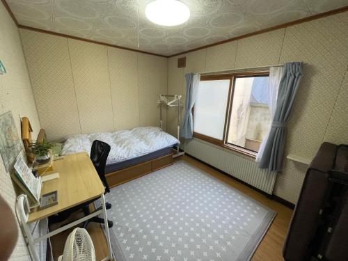 a small room with a bed and a window at EZO HOUSE in Kawayu