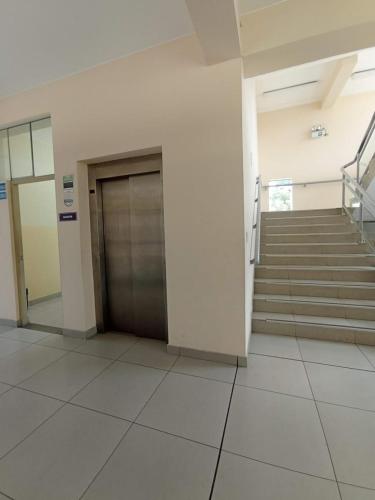 a hallway with a door and stairs in a building at Paradise Grand Hotel Delhi igi Airport in Etāwah