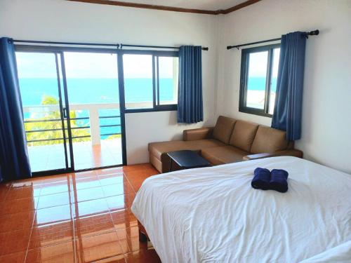 a bedroom with a bed and a couch and a balcony at Magic View Apartments Koh Tao in Ko Tao
