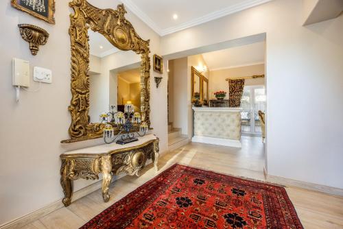 an ornate gold mirror on a wall in a living room at 17 On Cedar Boutique Guesthouse in Durbanville