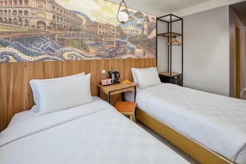 two beds in a hotel room with a mural at Go Hotels Iloilo in Iloilo City
