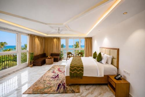 a hotel room with a bed and a balcony at White Wharf Beach Resort Morjim Goa in Morjim