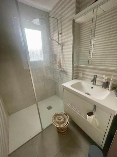 a white bathroom with a sink and a shower at Maison huit places Piscine tennis Lacanau plage in Lacanau