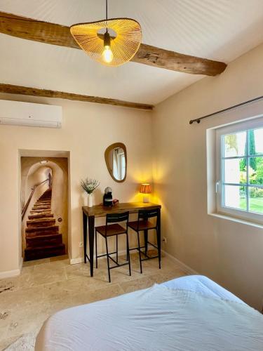 a bedroom with a bed and a desk and a staircase at Mas du Rocan in Aubignan