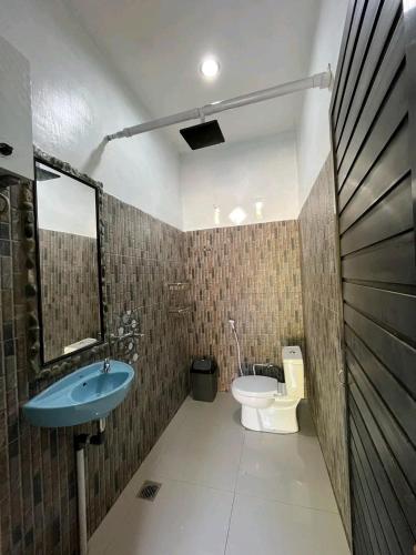 a bathroom with a sink and a toilet at Bukit Lawang Orangutan Dormitory in Bukit Lawang