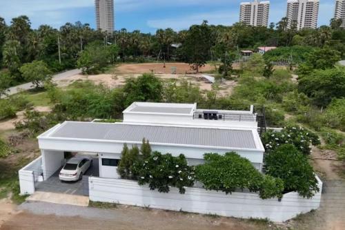 a white house with a car parked in front of it at Cha-am Pool Villa in Ban Bo Prakhon