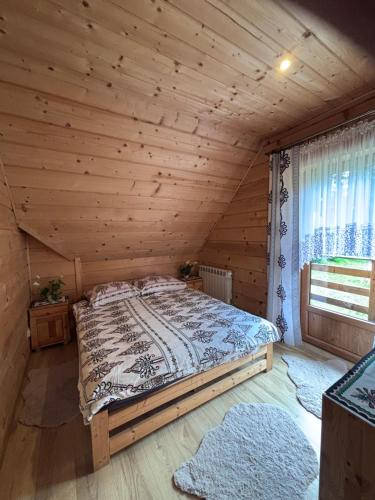 a bedroom with a bed in a wooden cabin at Gościniec Dziubasowki in Nowy Targ