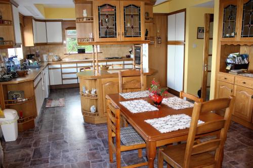 a kitchen with a wooden table and chairs at Kilsallagh Cottage in Westport