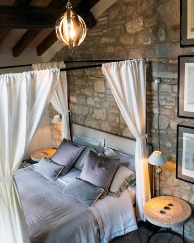 a bedroom with a bed with white curtains at Borgo Vercallo in Case la Selva