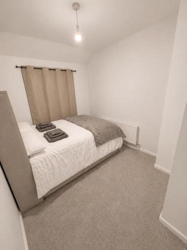 a bedroom with a bed in a white room at Newly Refurbished 3-Bed Sleeps 5 in Lostock