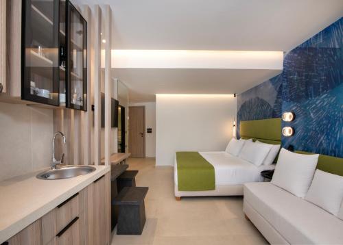 ein Hotelzimmer mit einem Bett und einer Couch in der Unterkunft Leonidas Hotel & Apartments in Rethymno
